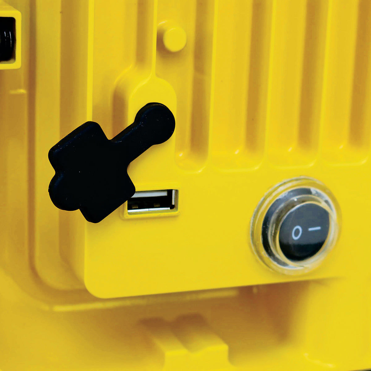 Close-up of a yellow switch panel with a black toggle switch and power button.